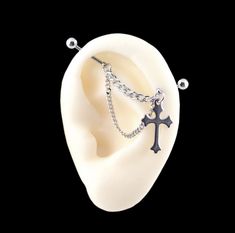 an ear with a chain attached to it and a cross hanging from the middle of it