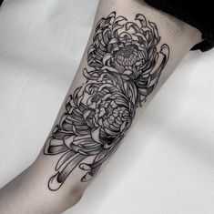 a black and white flower tattoo on the leg