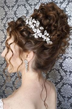 a woman wearing a hair comb with flowers on it's head in front of a wall