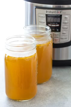 two jars filled with liquid next to an instant pot