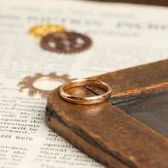 two wedding rings sitting on top of an open book