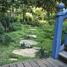 a wooden deck with stepping stones in the grass