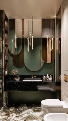 a bathroom with marble floors and green walls, along with gold mirrors on the wall