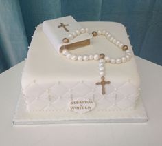 a cake decorated with pearls and a cross