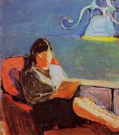 a woman sitting in a chair reading a book