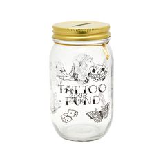 a glass jar filled with lots of tattoos on the lid and gold rimmed top