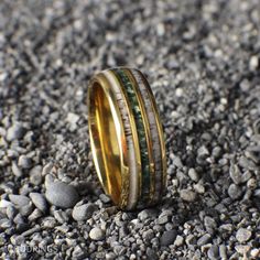 two different colored rings sitting on top of some rocks next to each other and gravel