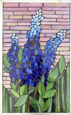 a painting of blue flowers in front of a brick wall