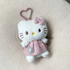 a hello kitty keychain with a pink dress on it