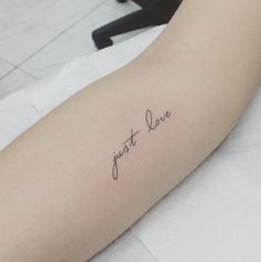 a woman's arm with the words just love tattooed on her left arm, in cursive font