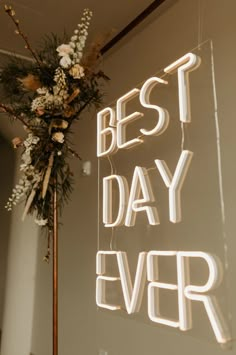 a sign that says best day ever with flowers on top and the words best day ever below it