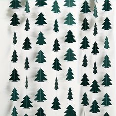 paper christmas trees are hanging on a white wall with green trimmings and black dots