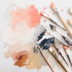 an assortment of paintbrushes sitting on top of a white surface