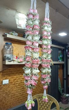 some pink and white cupcakes hanging from a chandelier in a kitchen