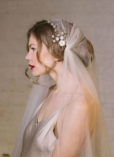 a woman in a wedding dress with a veil on her head