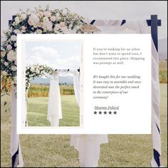 a wedding dress hanging from a white and blue arch with flowers on it, in front of an open field