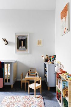 a child's room with toys and bookshelves in the corner, including a toy table