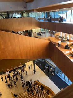 an overhead view of people walking around in a large building with wooden floors and staircases