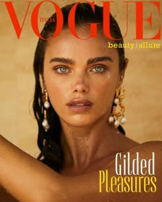 a woman with blue eyes is featured on the cover of a magazine, wearing gold jewelry