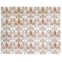 a white and brown tile wall with an ornate design on it's back side