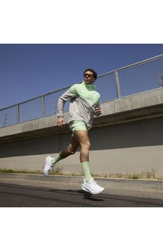 a man running down the street wearing green socks