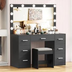 a vanity with lights on it and a stool in front of the mirror that is open