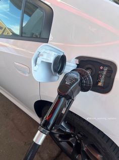 an electric car being charged by a charger at a gas station in the united states