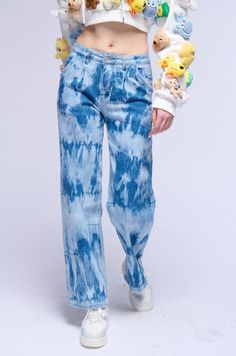 a woman wearing blue jeans with stuffed animals on them