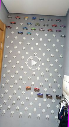 a room filled with lots of toy cars next to a wall mounted on the wall