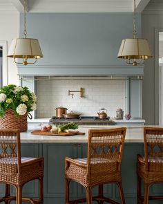 two wicker chairs sit in front of a kitchen island