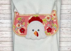 a white towel with a chicken applique on it