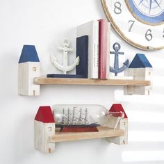 two wooden shelves with books, an anchor and a ship in them on the wall