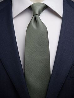 a man wearing a suit and green tie