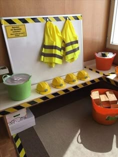 there is a table with yellow and black items on it, including two buckets