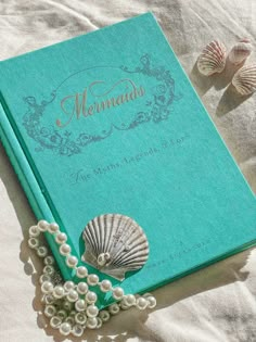 a book with pearls and a sea shell