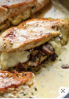 two pieces of chicken with cheese and mushrooms in a casserole on a plate