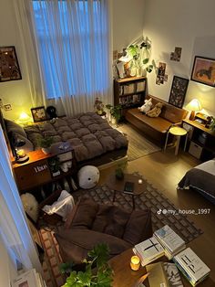 a living room filled with lots of furniture next to a window covered in sheer curtains