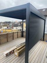 an outdoor area with wooden decking and blue awning