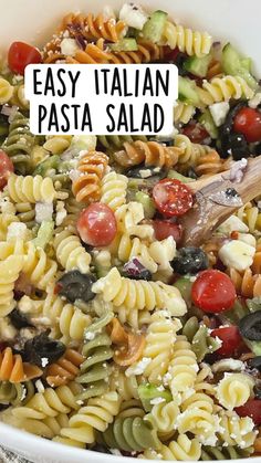 pasta salad in a white bowl with a wooden spoon