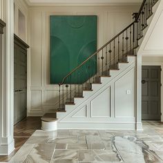 a staircase leading up to a green painting on the wall in a room with white walls