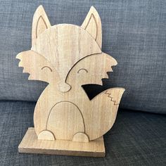 a wooden sculpture of a fox sitting on top of a couch