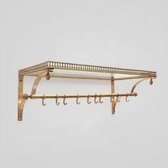 a coat rack with hooks on it against a white wall