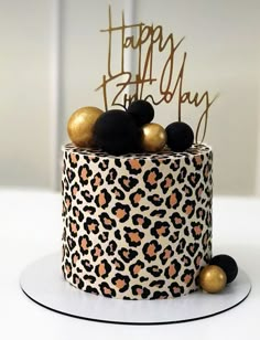 a leopard print birthday cake with gold and black decorations