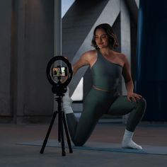 a woman squatting in front of a camera