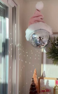 a disco ball hanging from the ceiling next to a christmas tree and other holiday decorations