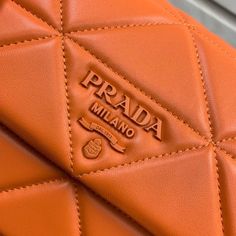 an orange leather bag with the word prada on it's side pocket and logo