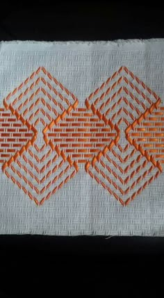 an orange and white piece of cloth with some stitching on it