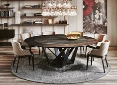 a round table with chairs around it in front of a book shelf and chandelier