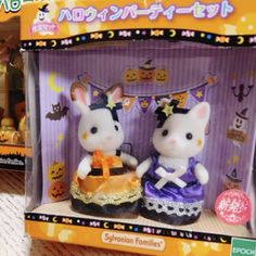 two small figurines are sitting in a box