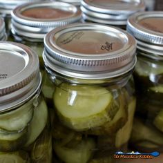 jars filled with pickles sitting on top of a table